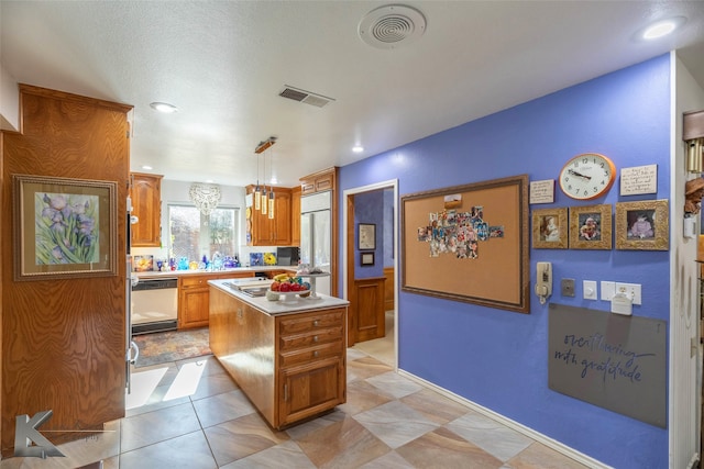 kitchen with dishwashing machine, visible vents, light countertops, and a center island