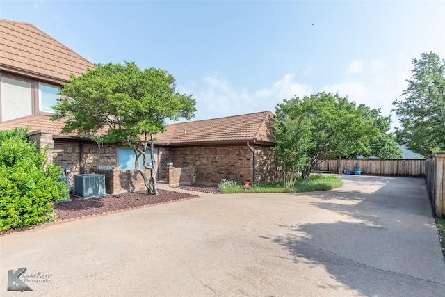 20 Glen Abbey St, Abilene, TX 79606 - view of front of house featuring cooling unit, a tiled roof, and brick siding