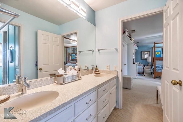 bathroom with double vanity, ensuite bath, a sink, and visible vents