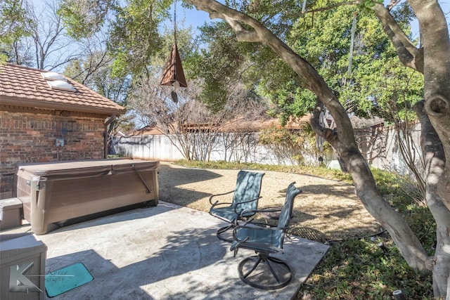 view of patio / terrace with a fenced backyard and a hot tub