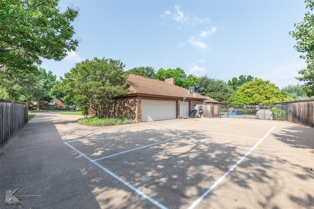 20 Glen Abbey St, Abilene, TX 79606 - view of side of property featuring a tile roof, an attached garage, a chimney, brick siding, and driveway
