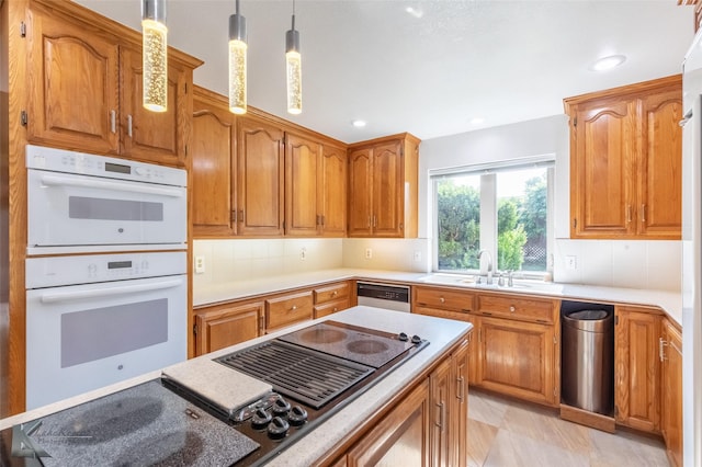 20 Glen Abbey St, Abilene, TX 79606 - kitchen featuring black electric cooktop, white double oven, pendant lighting, a sink, and backsplash