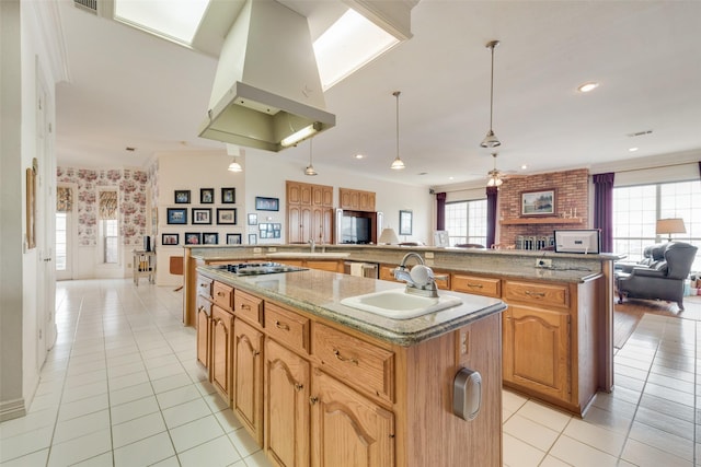 kitchen featuring a sink, ventilation hood, a large island with sink, and open floor plan