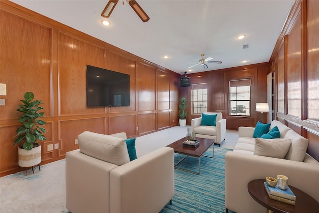 living room with recessed lighting, light colored carpet, a decorative wall, visible vents, and a ceiling fan