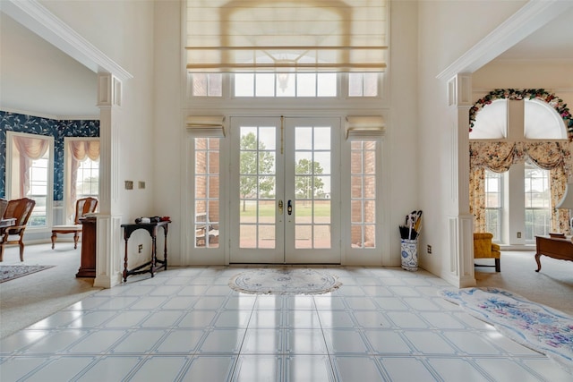 carpeted foyer entrance featuring french doors, a healthy amount of sunlight, and a towering ceiling