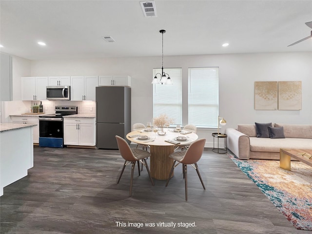 interior space featuring dark wood-style floors, recessed lighting, visible vents, and a notable chandelier