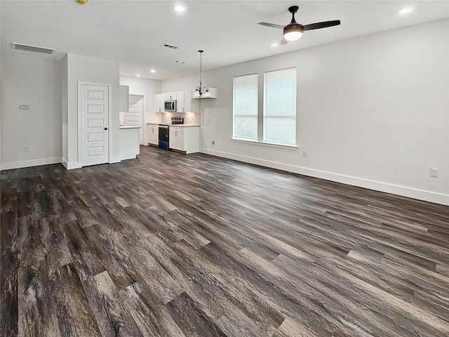 unfurnished living room featuring dark wood-style floors, visible vents, and baseboards