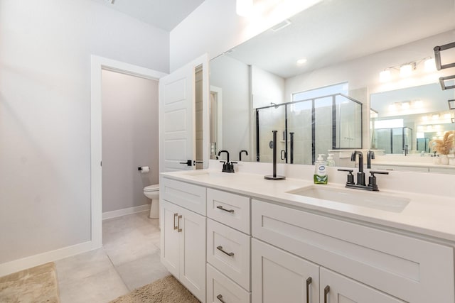 bathroom with double vanity, a sink, toilet, and a shower stall