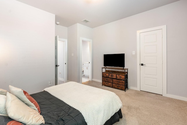 bedroom with light colored carpet, visible vents, baseboards, and ensuite bathroom