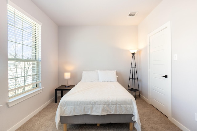 bedroom with light carpet, baseboards, and visible vents