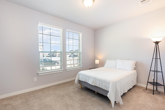 bedroom with light carpet, visible vents, and baseboards