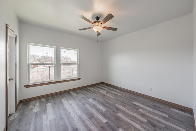 spare room with a ceiling fan, baseboards, and wood finished floors