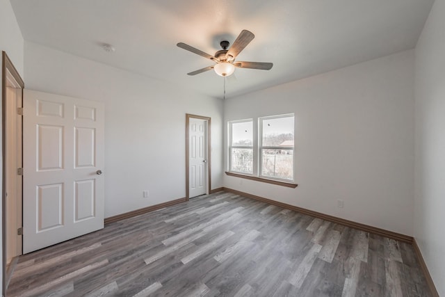 unfurnished bedroom with a ceiling fan, a closet, baseboards, and wood finished floors