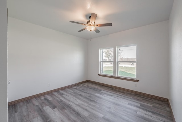 unfurnished room featuring ceiling fan, baseboards, and wood finished floors