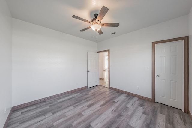 unfurnished room with a ceiling fan, light wood-style flooring, visible vents, and baseboards