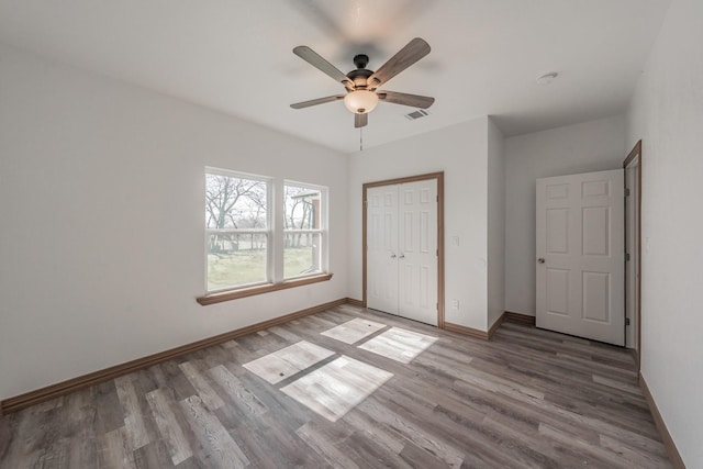 unfurnished bedroom with light wood finished floors, baseboards, visible vents, and a closet