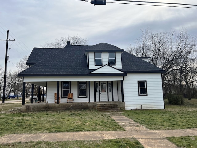 view of front facade with covered porch, a front lawn, and a shingled roof