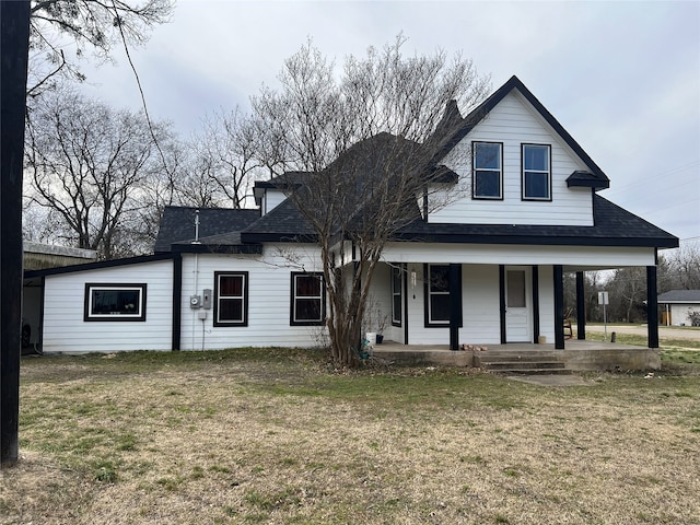 view of front of home with roof with shingles, a porch, and a front lawn