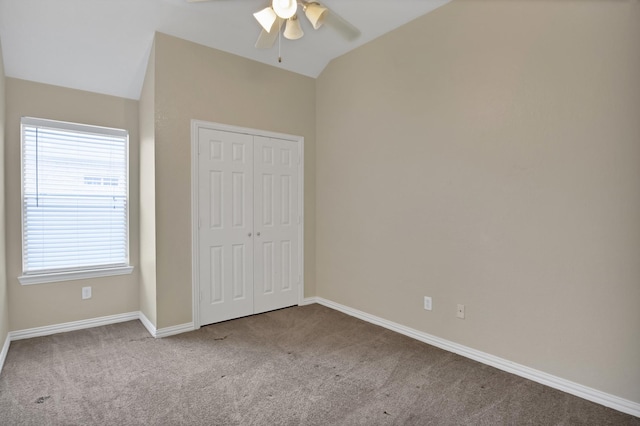 unfurnished bedroom with baseboards, a ceiling fan, lofted ceiling, carpet, and a closet