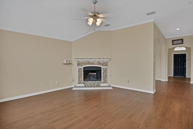 unfurnished living room featuring a fireplace with raised hearth, wood finished floors, visible vents, baseboards, and crown molding