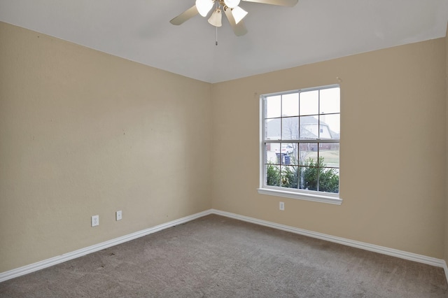 carpeted spare room with baseboards and a ceiling fan