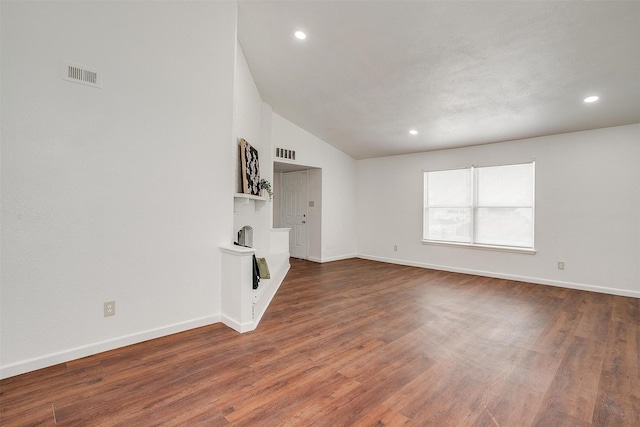 unfurnished living room featuring wood finished floors, visible vents, and baseboards