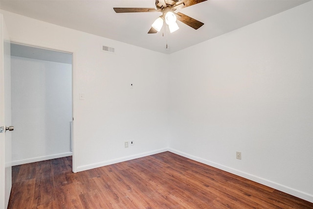 unfurnished room with baseboards, visible vents, ceiling fan, and wood finished floors