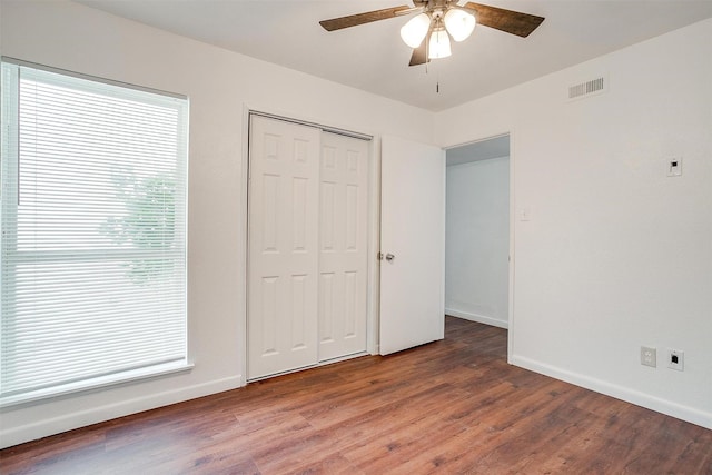 unfurnished bedroom featuring visible vents, baseboards, and wood finished floors