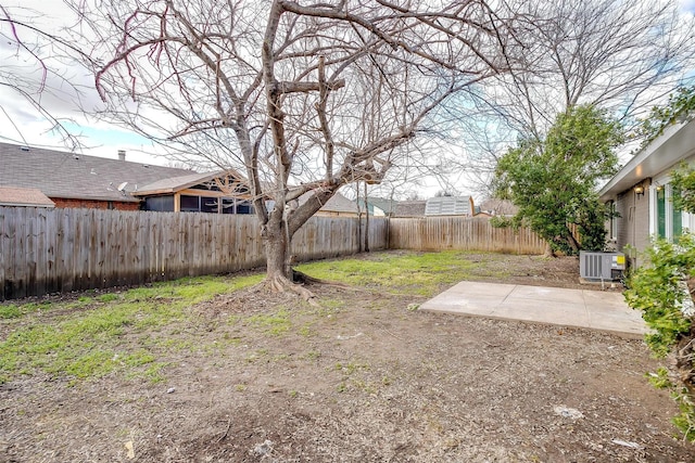 view of yard featuring a patio, central AC unit, and a fenced backyard