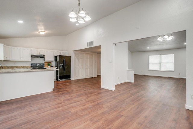 kitchen featuring range hood, visible vents, open floor plan, white cabinets, and black appliances