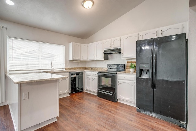 kitchen with lofted ceiling, white cabinetry, a sink, under cabinet range hood, and black appliances