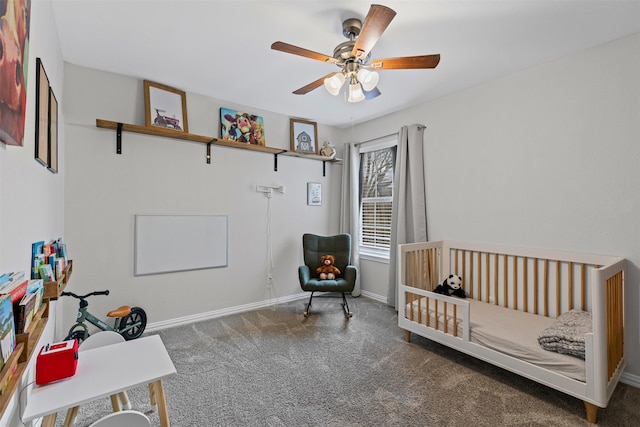 carpeted bedroom featuring a crib, ceiling fan, and baseboards