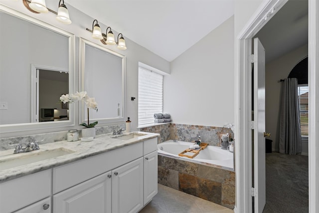 full bathroom featuring vaulted ceiling, double vanity, a sink, and a bath