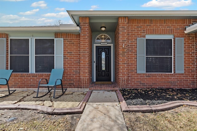 entrance to property featuring brick siding