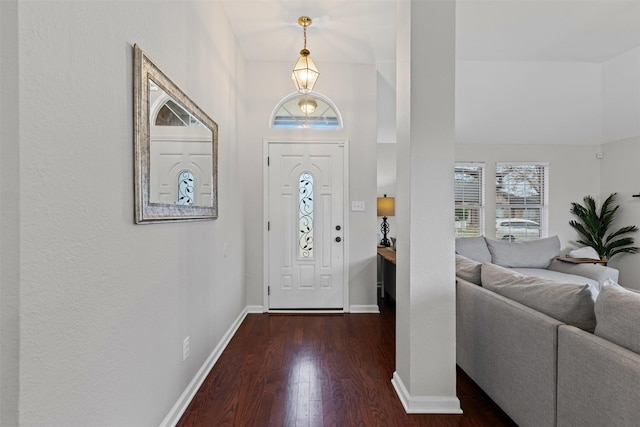 entryway featuring baseboards and dark wood finished floors