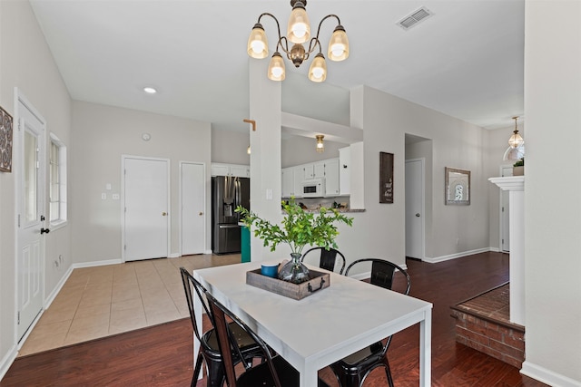 dining area with visible vents, baseboards, and wood finished floors