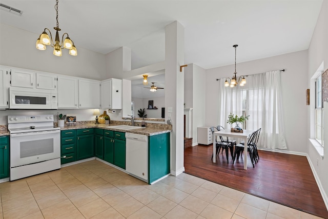 kitchen with white appliances, light tile patterned floors, visible vents, white cabinetry, and a sink