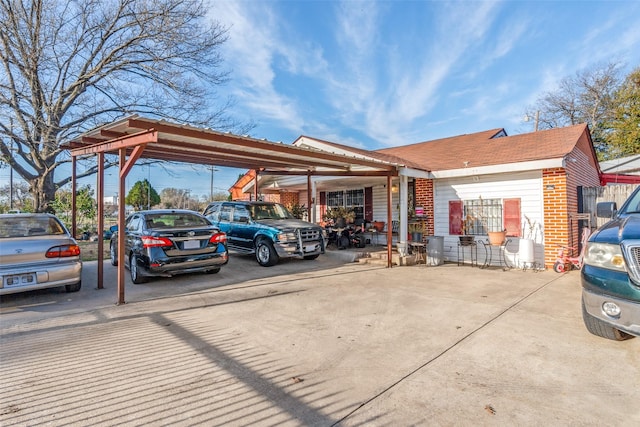 view of parking / parking lot featuring concrete driveway and a carport