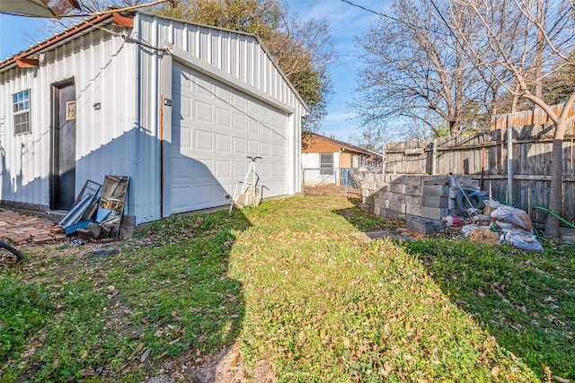 view of yard featuring an outdoor structure, fence, and a garage