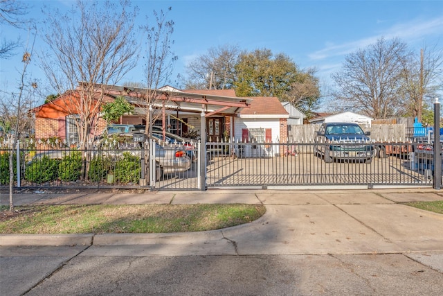 view of front of property with a fenced front yard, brick siding, and a gate