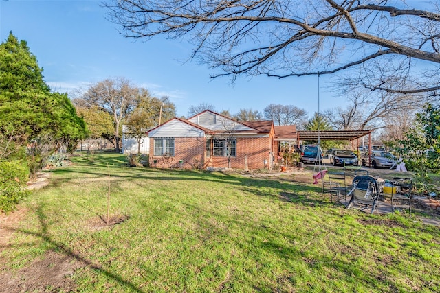 exterior space with brick siding, a front yard, and a carport