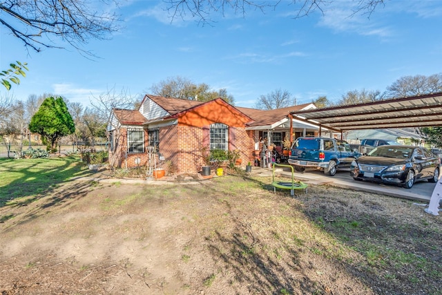 exterior space with a detached carport, a yard, and brick siding