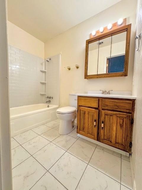 bathroom featuring toilet, marble finish floor, vanity, and shower / bathtub combination