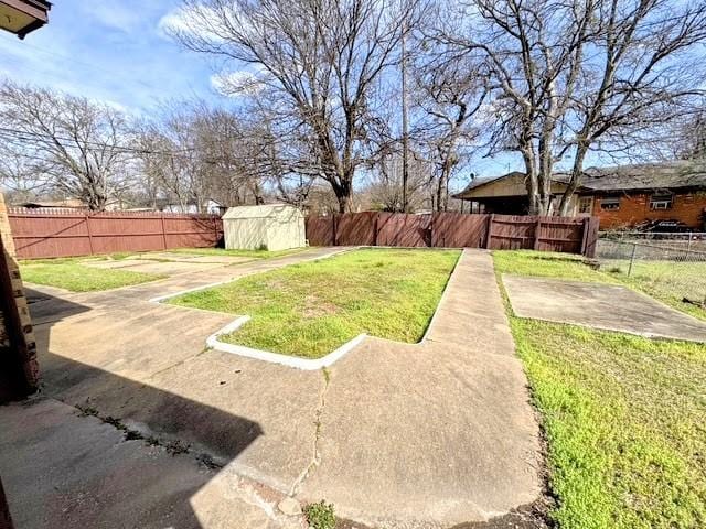 view of yard featuring a fenced backyard, an outdoor structure, a patio, and a storage unit