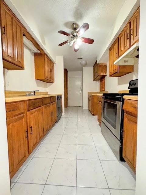 kitchen featuring brown cabinets, stainless steel electric stove, light countertops, under cabinet range hood, and dishwashing machine