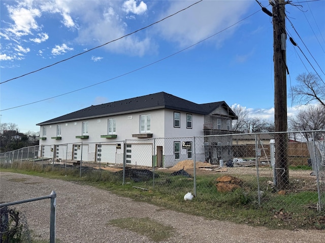 back of house with fence and stucco siding