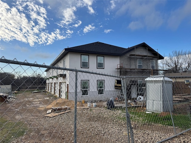 rear view of house with fence and stucco siding