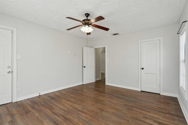 unfurnished bedroom featuring dark wood-type flooring, visible vents, and baseboards