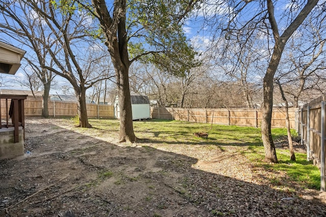 view of yard with an outbuilding, a shed, a patio area, and a fenced backyard