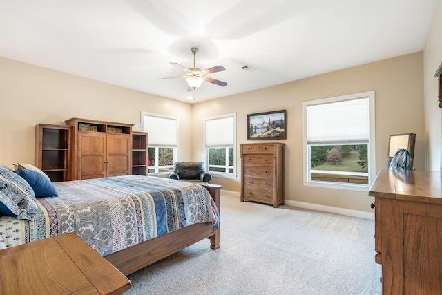 bedroom featuring light carpet, ceiling fan, visible vents, and baseboards